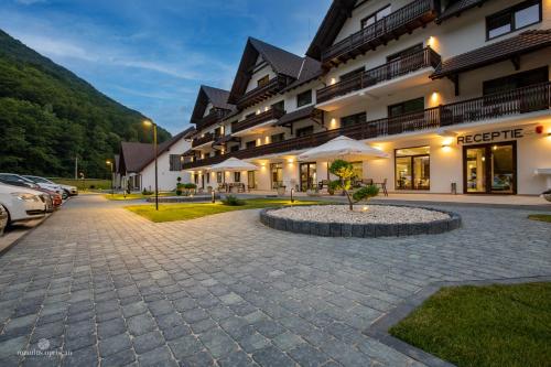 a hotel with a courtyard in front of a building at Nedei Hotel&Spa Transalpina in Martinie