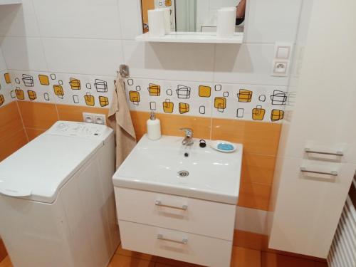 W białej łazience znajduje się umywalka i lustro. w obiekcie Apartmán pod kostelem w mieście Strážov