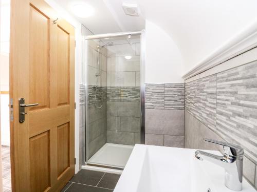 a bathroom with a shower and a sink at The Marriage Room at The Institute Executive Apartments in Keith