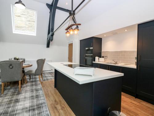 a kitchen with black cabinets and a white counter top at The Clock Tower at The Institute Executive Apartments in Keith