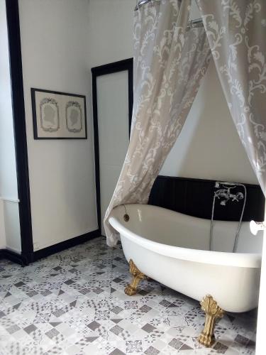 La salle de bains est pourvue d'une baignoire et d'un rideau de douche. dans l'établissement Les Cèdres, à Montaigu-Vendée