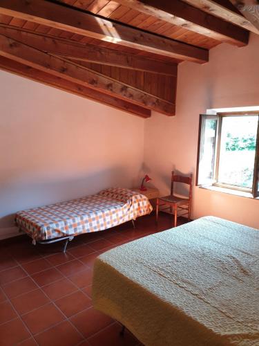 a bedroom with two beds and a table and a window at Appartamento Rosy in Fiumalbo