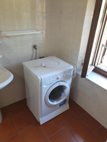 uma máquina de lavar roupa na casa de banho com uma janela em Appartamento Rosy em Fiumalbo