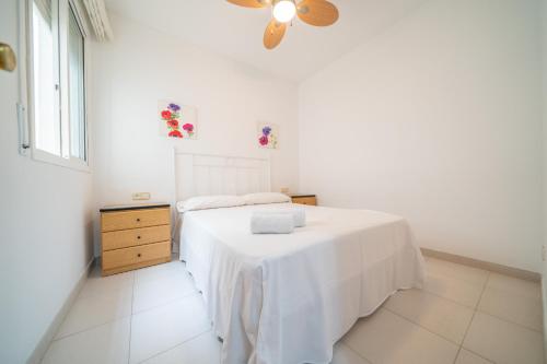 ein weißes Schlafzimmer mit einem Bett mit einer weißen Decke in der Unterkunft HomeHolidaysRentals Margot - Costa Barcelona in Pineda de Mar