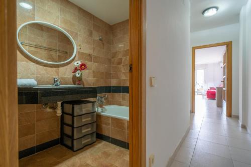 ein Badezimmer mit einem Waschbecken, einer Badewanne und einem Spiegel in der Unterkunft HomeHolidaysRentals Margot - Costa Barcelona in Pineda de Mar