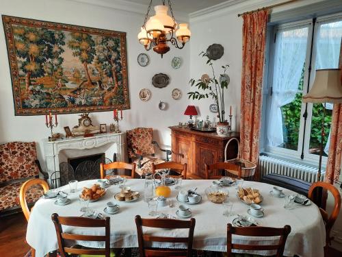une salle à manger avec une table et une cheminée dans l'établissement Les Cèdres, à Montaigu-Vendée