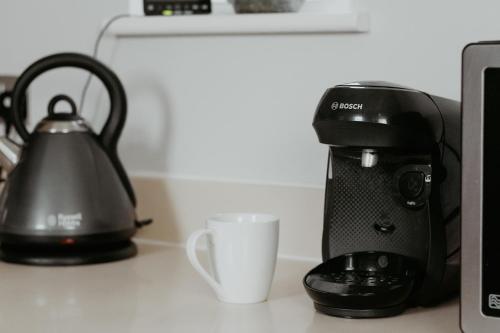 a coffee maker and a cup on a counter at 2 The Mews, Upper Bath Street in Cheltenham