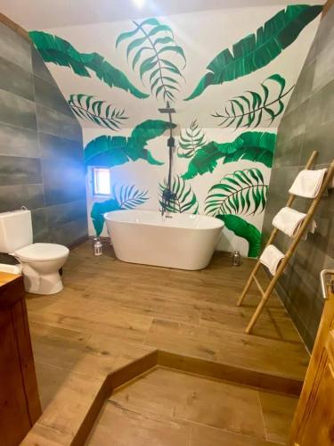a bathroom with a white tub and green plants on the wall at Intense Room in Remeţi