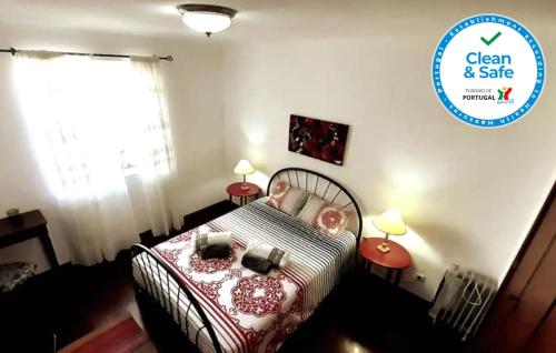 a bedroom with a bed and two tables with lamps at Apartamento Beira-Mar in Ribeira Grande