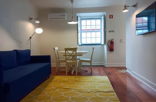 salon ze stołem i niebieską kanapą w obiekcie Apartamentos Ázera - Lígia Ázera w mieście Praia da Vitória