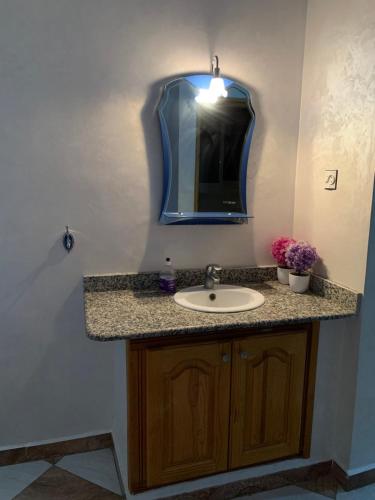 La salle de bains est pourvue d'un lavabo et d'un miroir. dans l'établissement Appartement Mus saidia 1, à Saïdia