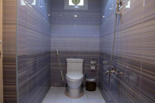 a bathroom with a white toilet in a room at ماجيك سويت بلس Magic Suite PLus in Kuwait