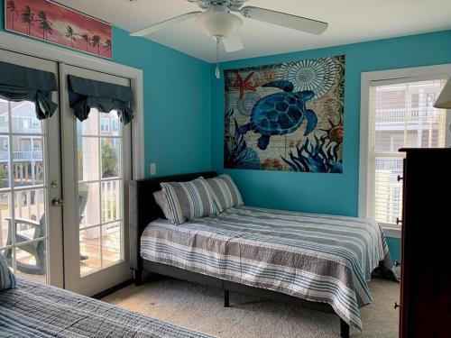 a bedroom with a bed and a painting on the wall at 2 the C in Holden Beach
