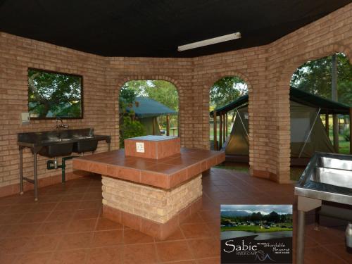 a patio with a sink and a counter in a building at Sabie River Camp in Sabie