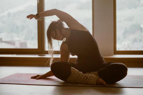 a woman sitting on the floor doing a yoga pose at Hotel Blü Gastein in Bad Hofgastein