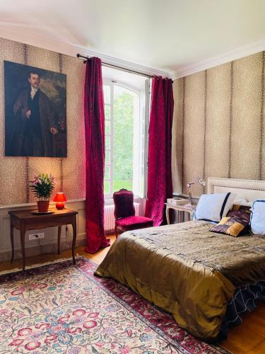 une chambre avec un lit et un portrait d'homme dans l'établissement Château de Trébons, à Grainville-Ymauville