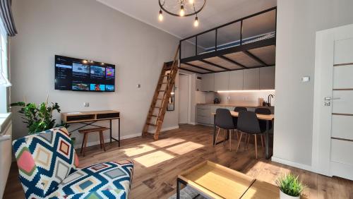 a living room with a kitchen and a loft at Antresola - Apartamenty Parkowe in Gniezno