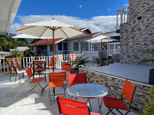 a patio with tables and chairs and an umbrella at Hotel Geronimo in Pucón