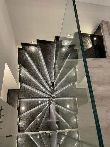 una escalera de caracol en una casa con barandilla de cristal en STAR Apartment PIRAN en Piran