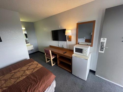 een hotelkamer met een bed en een bureau met een magnetron bij Extend-A-Suites Albuquerque West in Albuquerque
