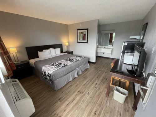 a hotel room with a bed and a television at Rodeway Inn Albuquerque West in Albuquerque
