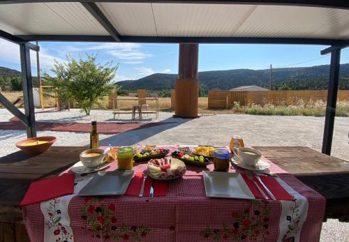 una mesa de picnic con comida y bebidas. en Burbuja AntiSaturno - Glamping Alto Tajo, en Ablanque