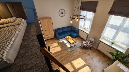 una vista aérea de una sala de estar con un sofá azul en Apartament Parkowy Antresola en Gniezno
