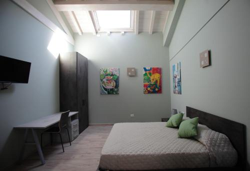 a bedroom with a bed with green pillows and a desk at La CASA DEGLI ARTISTI in Tuscania