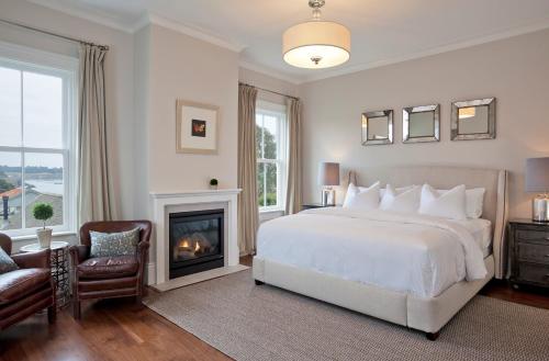 a bedroom with a white bed and a fireplace at Inns of Mendocino in Mendocino