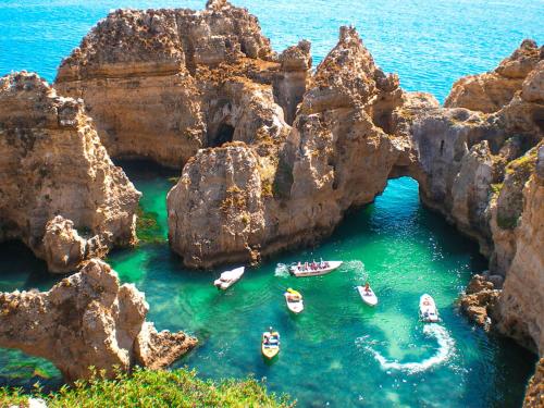 a group of boats in the water near some rocks at Agua de Sonho 2 in Bensafrim