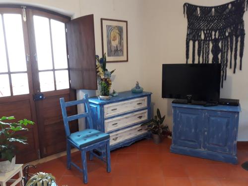 sala de estar con TV y silla azul en Agua de Sonho 2, en Bensafrim