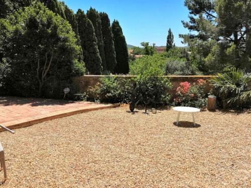 una mesa blanca en un jardín con árboles y arbustos en Chambre d'Hôtes au Domaine du Soleil Couchant, en Saint-André-de-Roquelongue