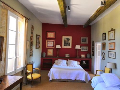 a bedroom with a white bed and a red wall at Chambre d'Hôtes au Domaine du Soleil Couchant in Saint-André-de-Roquelongue