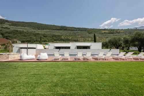 a group of white chairs sitting on a lawn at OLEEVA Garda Living - Adults Only in Riva del Garda