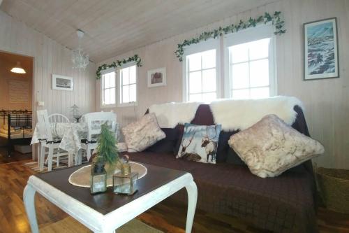 a living room with a couch and a table at Cosy Cottage-Álfabakki-with hot tub in Stóri-Bakki