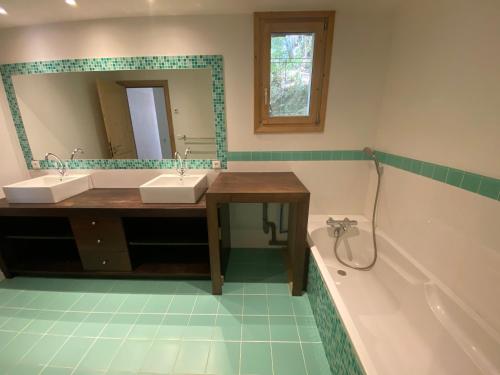 a bathroom with two sinks and a mirror and a tub at Casa Vitale Villard du Planay in Planay