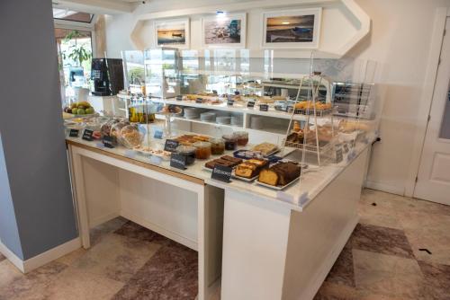 un mostrador de panadería con varios pasteles en exposición en Hotel Faro de San Vicente, en San Vicente de la Barquera
