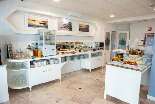 a kitchen with white cabinets and a counter with food at Hotel Faro de San Vicente in San Vicente de la Barquera