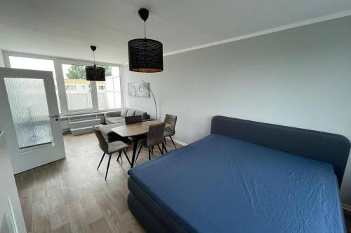 a bedroom with a blue bed and a table and chairs at Ferienwohnung an der Ostsee in Rostock