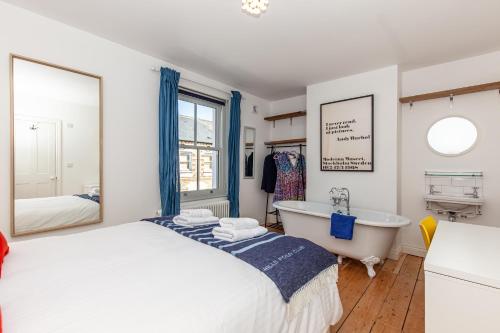 a bedroom with a bed and a tub and a window at Oxfordshire Living - The Cranham House - Oxford in Oxford