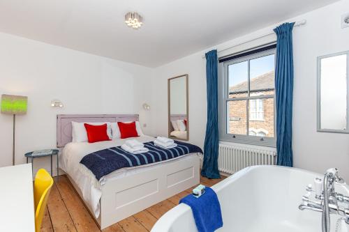 a bedroom with a bed and a tub and a window at Oxfordshire Living - The Cranham House - Oxford in Oxford