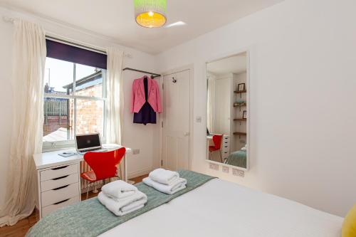 a white bedroom with a desk and a red chair at Oxfordshire Living - The Cranham House - Oxford in Oxford