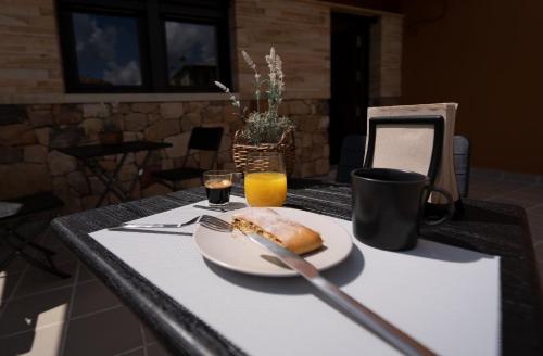 ein Tisch mit einem Teller Essen und einem Glas Orangensaft in der Unterkunft Hotel Rural La Casa de Mis Abuelos in Navaleno