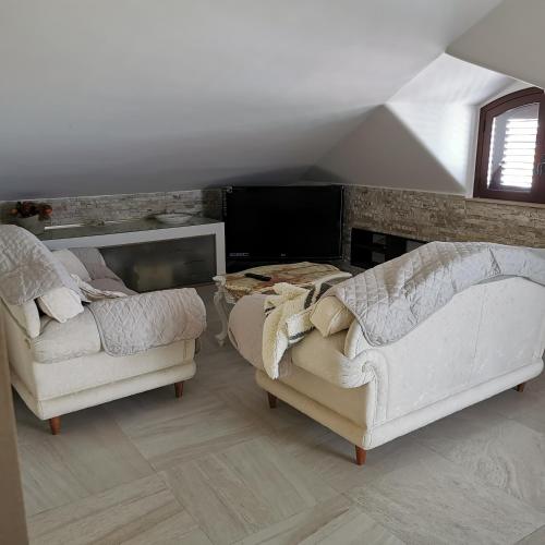 a living room with two white couches and a fireplace at Residence Villa candida in Giardini Naxos