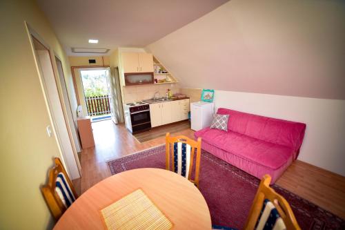 a living room with a pink couch and a table at Vikendica Kostic in Zlatibor