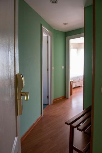 an empty room with green walls and a wooden floor at Hotel Faro de San Vicente in San Vicente de la Barquera