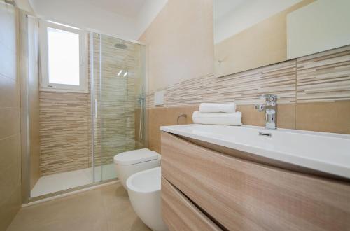 y baño con lavabo, aseo y ducha. en Case Vacanza Apollo en Torre San Giovanni Ugento