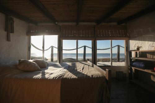 1 dormitorio con 1 cama y vistas al océano en Ventanas al Mar, en Cabo Polonio