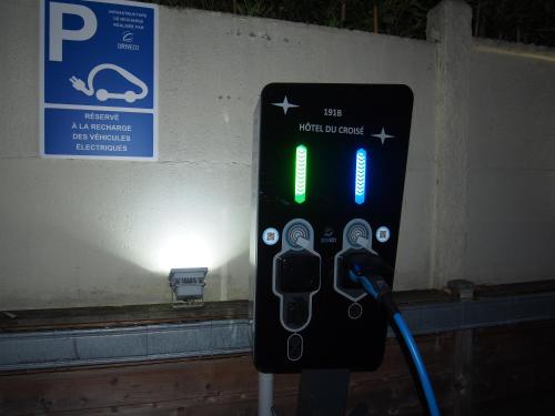 a sign for a parking meter in front of a wall at Hotel Du Croisé in Marcq-en-Baroeul