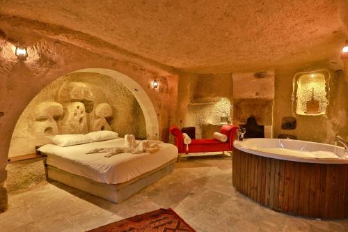 a bedroom with a bed and a bath tub at Cappadocia Eagle Cave Inn in Nevsehir